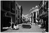People carry garnments in  Rodeo Drive shopping district. Beverly Hills, Los Angeles, California, USA ( black and white)
