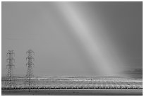 Rainbow, orchard in bloom, and power lines. California, USA ( black and white)