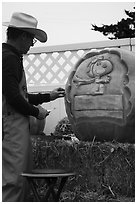 Man carving elaborate pumpkin. Half Moon Bay, California, USA ( black and white)