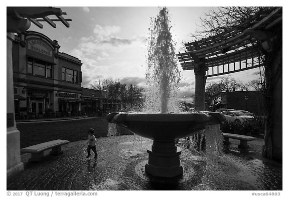 Fountain and plaza with child playing. Livermore, California, USA (black and white)