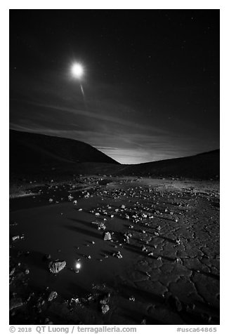 Puddle and cracked mud in Amboy Crater at night. Mojave Trails National Monument, California, USA (black and white)