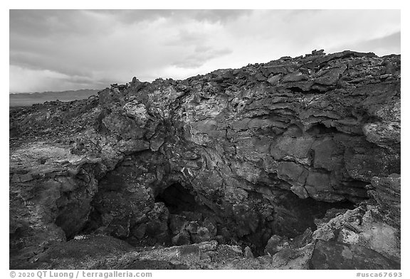 Depression and entrance to lava tube cave. Mojave Trails National Monument, California, USA (black and white)