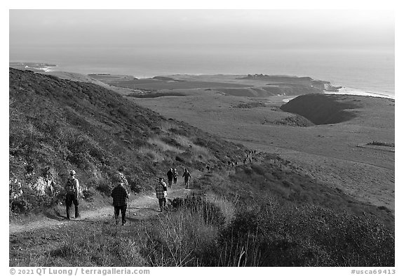 Group hiking above grassy marine coastal terrace. Cotoni-Coast Dairies Unit, California Coastal National Monument, California, USA (black and white)