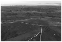 Aerial view of roads, gently rolling hills, with Pacific Ocean in the distance. California, USA ( black and white)