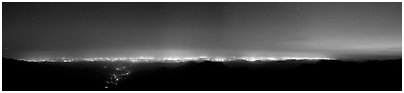 Central Valley lights at dusk seen from Morro Rock. California, USA (Panoramic black and white)