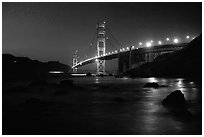 Golden Gate bridge and surf seen from E Baker Beach, night. San Francisco, California, USA ( black and white)