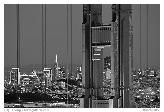 The city seen through the cables and pilars of the Golden Gate bridge, night. San Francisco, California, USA