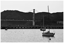 Sailboat in the Marina, with Golden Gate Bridge at sunset in the background. San Francisco, California, USA (black and white)