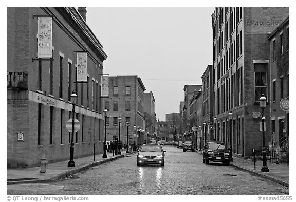 Downtown street lined with brick buildings in the rain, Lowell. Massachussets, USA