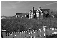 Fence and cottages in winter, Truro. Cape Cod, Massachussets, USA ( black and white)