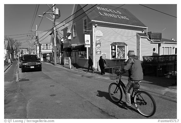 Woman biking on main street, Provincetown. Cape Cod, Massachussets, USA (black and white)