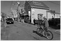 Woman biking on main street, Provincetown. Cape Cod, Massachussets, USA ( black and white)
