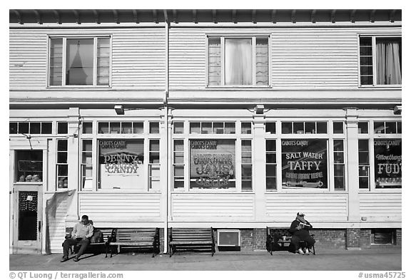 Men sitting in front of candy store, Provincetown. Cape Cod, Massachussets, USA (black and white)