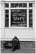 Man reading in front of Salt Water taffy store, Provincetown. Cape Cod, Massachussets, USA ( black and white)