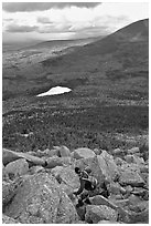Hiker descends from summit amongst boulders above treeline. Baxter State Park, Maine, USA (black and white)