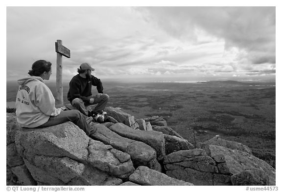 Hikers taking in view near sign marking summit of South Turner Mountain. Baxter State Park, Maine, USA