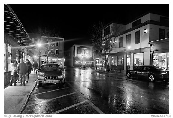 Street at night with people standing on sidewalk. Bar Harbor, Maine, USA