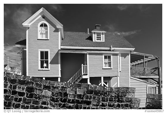Lobster traps lined in front of house. Stonington, Maine, USA (black and white)