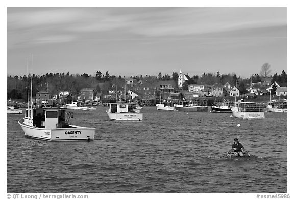 Man paddling to board lobster boat. Corea, Maine, USA