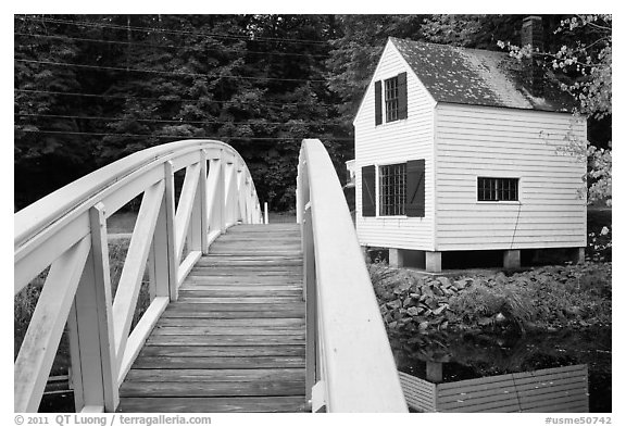 Wooden arched footbridge and house. Maine, USA