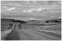 Gravel road, rolling hills and badlands. North Dakota, USA ( black and white)