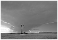 Windmill and tractor under a threatening stormy sky. North Dakota, USA ( black and white)
