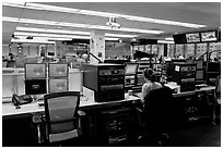 Bloomberg News analyst working in front of many screens. NYC, New York, USA (black and white)