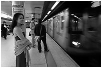 Young woman and arriving train on subway platform. NYC, New York, USA ( black and white)
