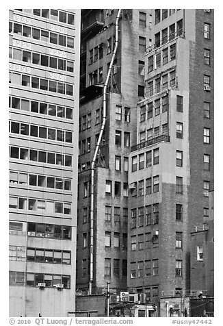 Old high-rise buildings with exterior pipe. NYC, New York, USA (black and white)