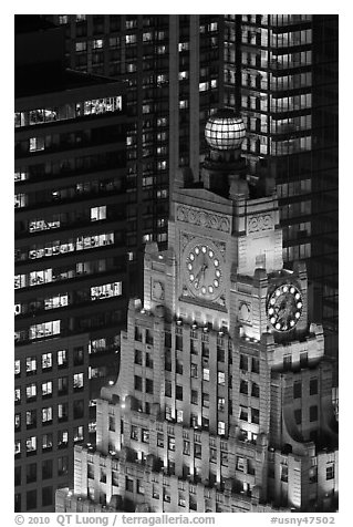 Top of vintage high-rise building with globe and clocks. NYC, New York, USA