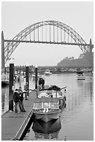 Couple holding small boat at boat lauch ramp. Newport, Oregon, USA (black and white)