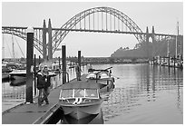 Couple holds  small boat on pier, Newport Marina. Newport, Oregon, USA (black and white)