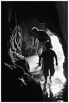 Boy and man exploring sea cave. Bandon, Oregon, USA (black and white)