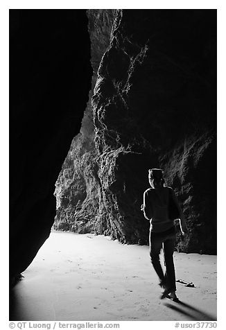 Woman walking out of sea cave. Bandon, Oregon, USA (black and white)