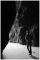 Woman walking out of sea cave. Bandon, Oregon, USA (black and white)