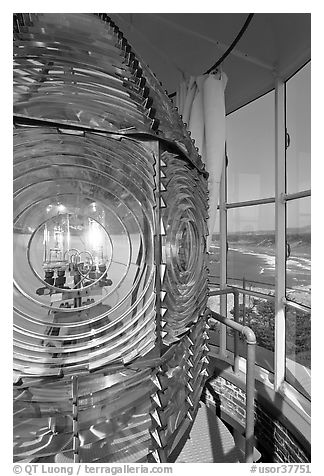 Rotating light inside Cape Blanco Lighthouse tower and landscape. Oregon, USA (black and white)