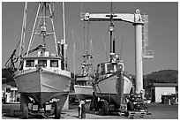 Fishing boats parked on deck with hoist behind, Port Orford. Oregon, USA ( black and white)