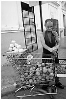 A man peels oranges to make an orange drink, which is drunk from the fruit itself, Ponce. Puerto Rico ( black and white)