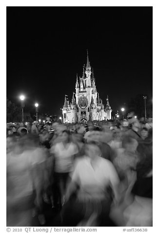 Crowds walking away from Cinderella Castle at night. Orlando, Florida, USA (black and white)