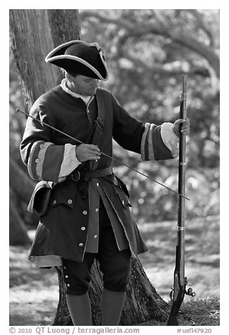 Man useing ramrod on musket, Fort Matanzas National Monument. St Augustine, Florida, USA (black and white)