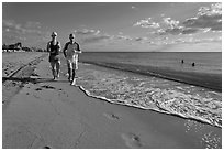 Couple jogging on beach,  Miami Beach. Florida, USA ( black and white)