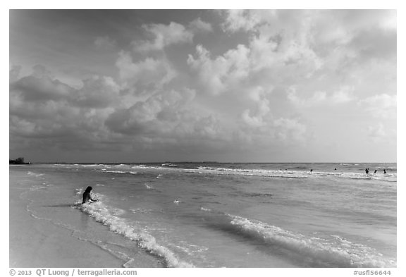 Woman sitting in water, Fort De Soto beach. Florida, USA (black and white)