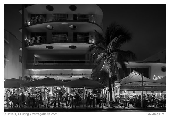 Restaurant tables and Art Deco buildings at night, Miami Beach. Florida, USA (black and white)