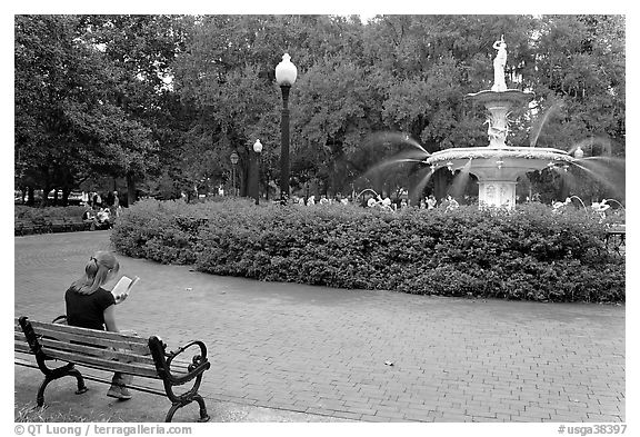 Forsyth Park Fountain with woman sitting on bench with book. Savannah, Georgia, USA (black and white)