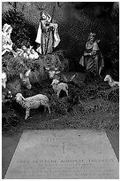 Tombstone of a French priest, and figures inside a replica of the Lourdes grotto, church Saint-Martin-de-Tours, Saint Martinville. Louisiana, USA ( black and white)