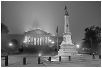 Monument to Confederate soldiers and state capitol at night. Columbia, South Carolina, USA (black and white)