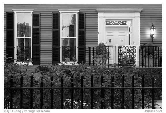 House facade at dusk with roses in front yard. Charleston, South Carolina, USA (black and white)