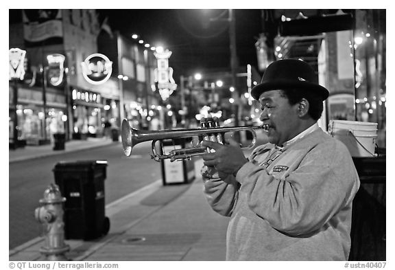 African-American man playing trumpet on Beale Street by night. Memphis, Tennessee, USA