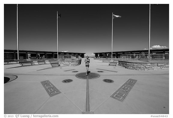 Woman straddling the territory of four states. Four Corners Monument, Arizona, USA