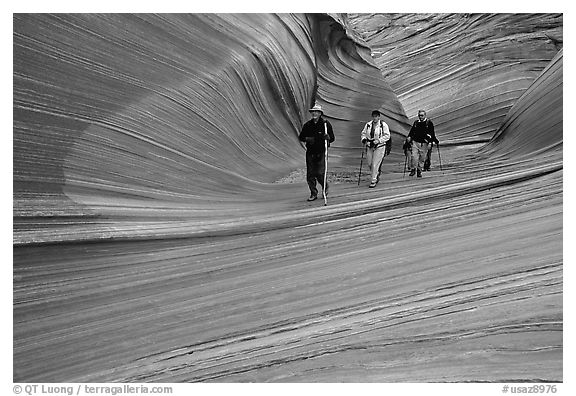 Hikers walk out of the Wave. Vermilion Cliffs National Monument, Arizona, USA (black and white)